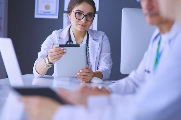 Serious medical team using a laptop in a bright office