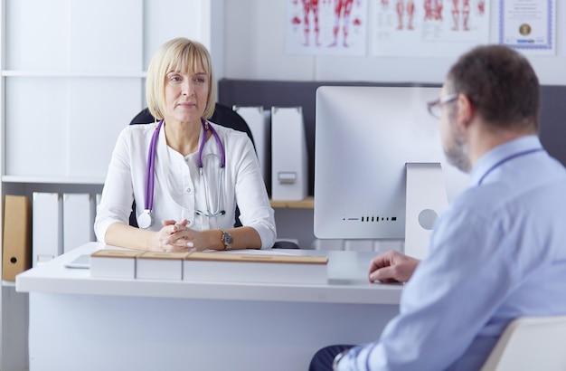 Serious medical team using a laptop in a bright office