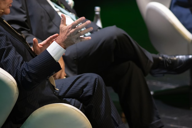 Serious men in suits sit at a conference