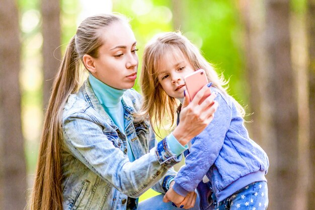 La madre seria si fa un selfie nella foresta giornata di sole estivo