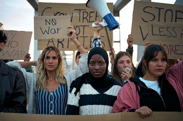 serious muslim woman in the middle of a demonstration by a group of activists people