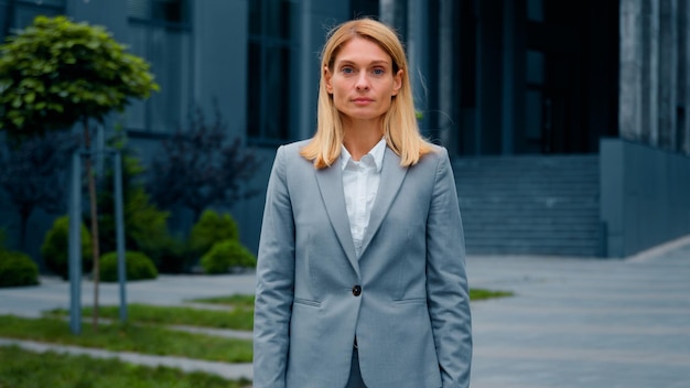 Serious pensive puzzled businesswoman standing outdoors caucasian woman
