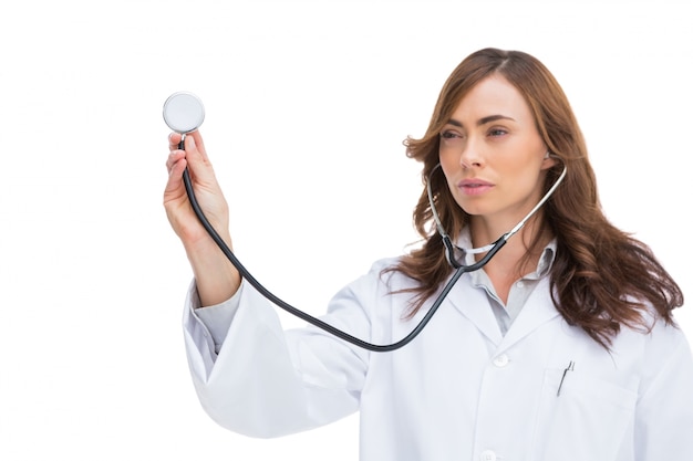 Serious pretty doctor holding stethoscope