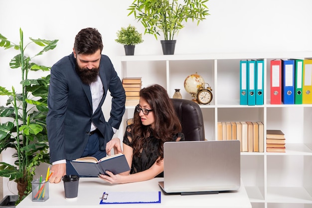 Serious professional couple of man and woman work on project in office, working.