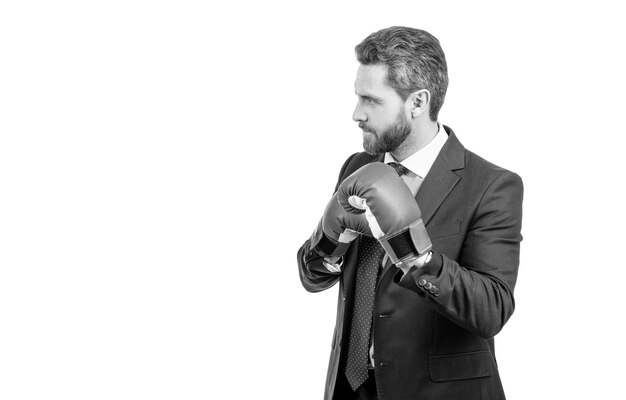 Serious professional man in boxing gloves and suit stand in fighting position fight