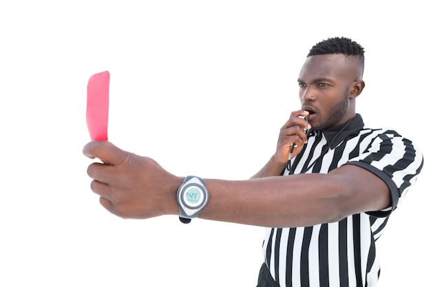 Serious referee showing red card blowing whistle