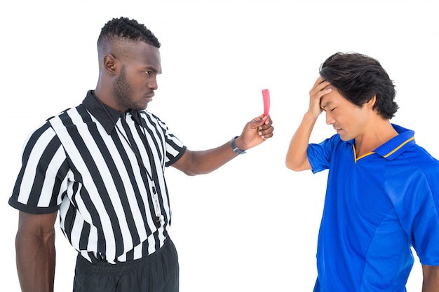 Serious referee showing red card to player