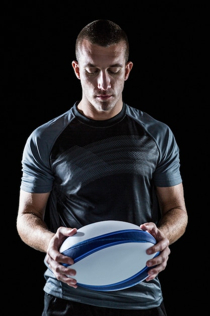 Serious rugby player holding ball