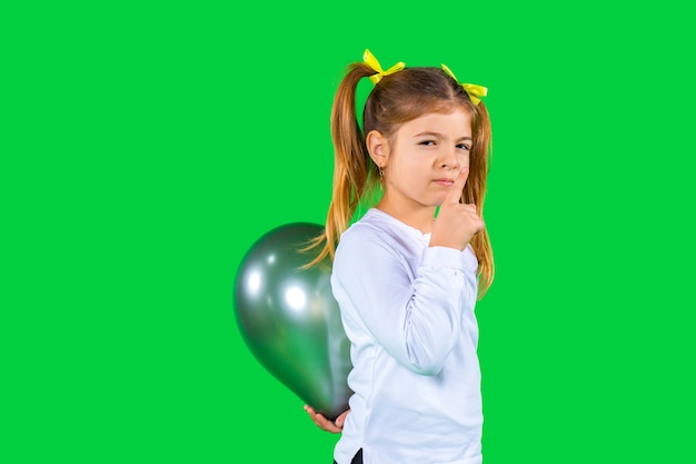 Serious school girl hides a ultimate gray balloon behind her back