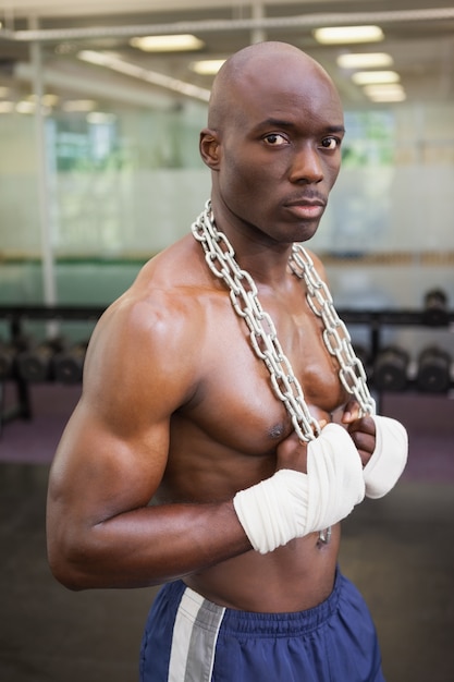 Serious shirtless muscular man in gym