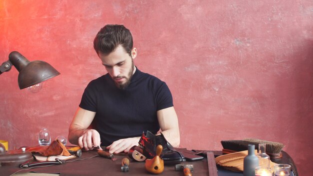 Photo serious shoemaker in the process for the manufacture of shoes