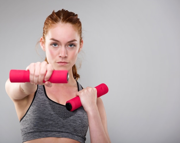 Serious sports woman holding weights