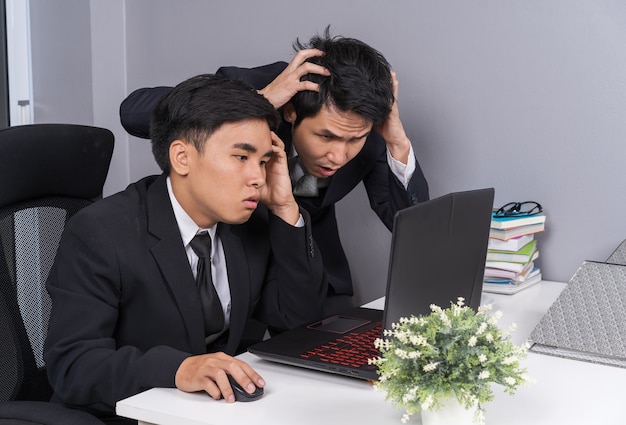 serious stressed two business man using laptop to working project