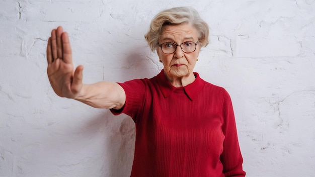 Серьезная и строгая старуха бабушка запрещает протянуть руку вперед в остановке отвержения или prohibi