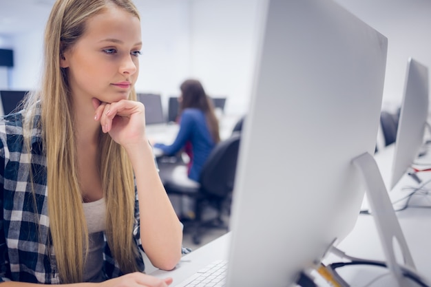 Serious student working on computer at university 