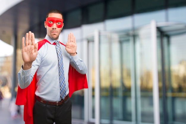 Serious super businessman doing a stop gesture