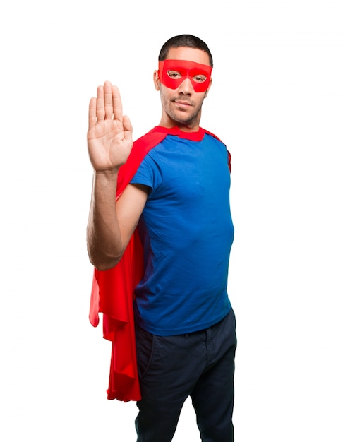 Serious superhero with a stop gesture