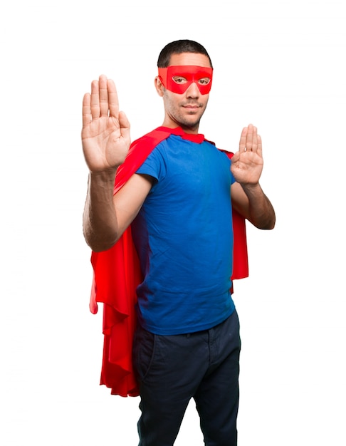 Serious superhero with a stop gesture