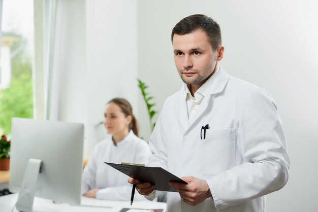 Serious surgeon with bristles holds a black clipboard