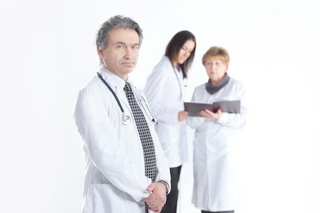 Serious therapist doctor on blurred background of colleagues