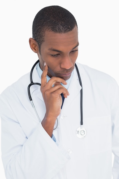 Serious thoughtful male doctor looking down