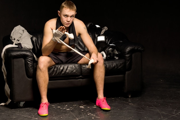 Serious thoughtful muscular young boxer preparing for a fight