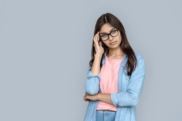 ひどく疲れたインド人女性がイライラした顔でカメラを見ています