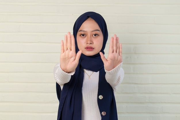 serious upset muslim woman showing stop hand gesture