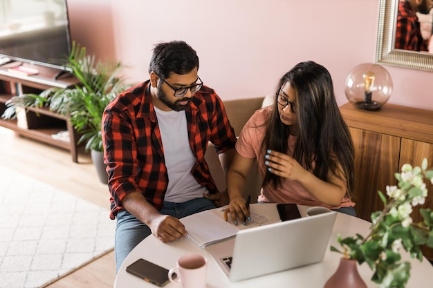 Serious wife and husband planning budget checking finances focused young woman using online calculat