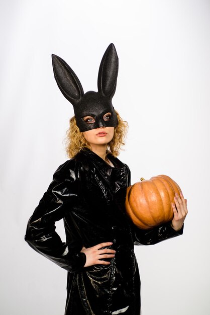 Serious woman in bunny mask with pumpkin sexy girl in halloween party woman in bunny mask with jack