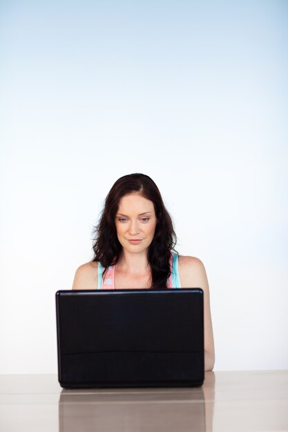 Серьезная женщина сосредоточена на своем ноутбуке с копией пространства