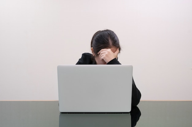 Serious woman grabbing her head  with stressed in front of laptop