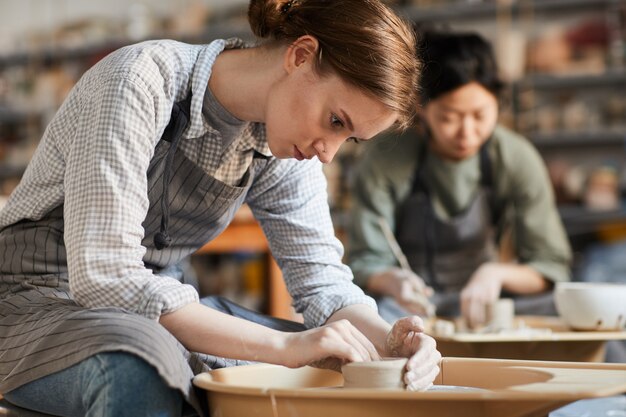 ワークショップで鍋を作る深刻な女性