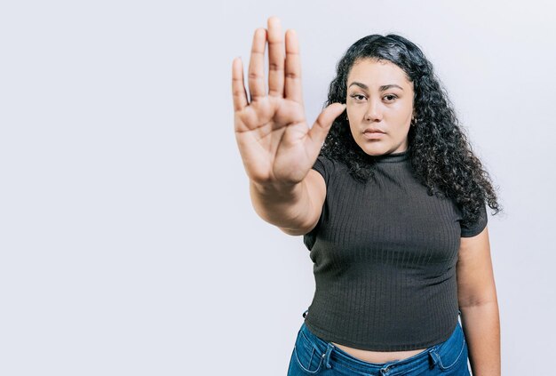 Foto donna seria che rifiuta con il palmo della mano isolato persone che gesticolano stop isolato donna latina che gesticola stop con il palmo della mano isolato