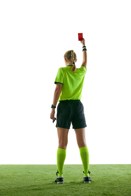 Фото Серьезная женщина-футбольный судья жестикулирует, поднимая руку, останавливая игру, и показывает красную карточку против