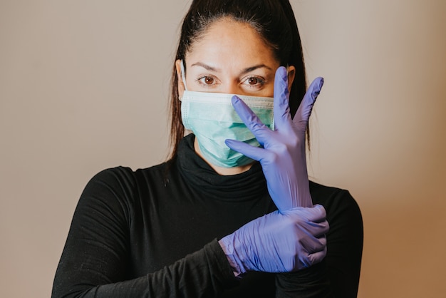 Photo serious woman wearing protection mask and gloves