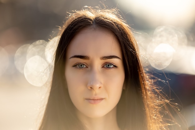 Foto la donna seria con lo sguardo pensieroso sta posando fuori per il ritratto