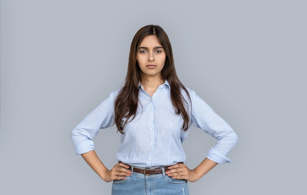 Serious young adult indian woman with hands on hips