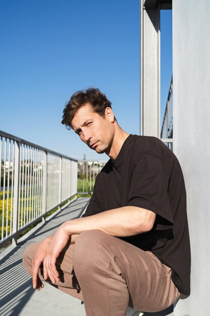 Serious young adult man wearing black tshirt on the street