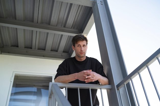 Serious young adult man wearing black tshirt on the street