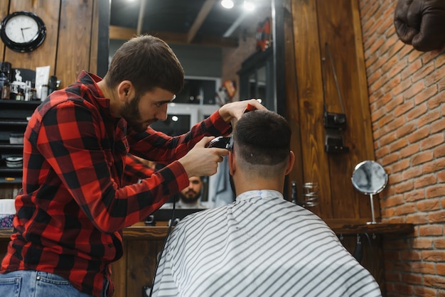 Serious Young Bearded Man Getting Haircut By Barber. Barbershop Theme