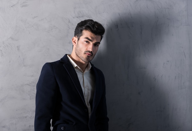 A serious young businessman in a black suit