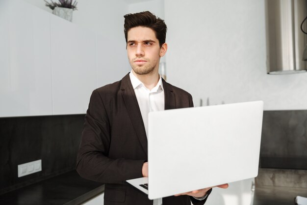 Serious young businessman using laptop computer.