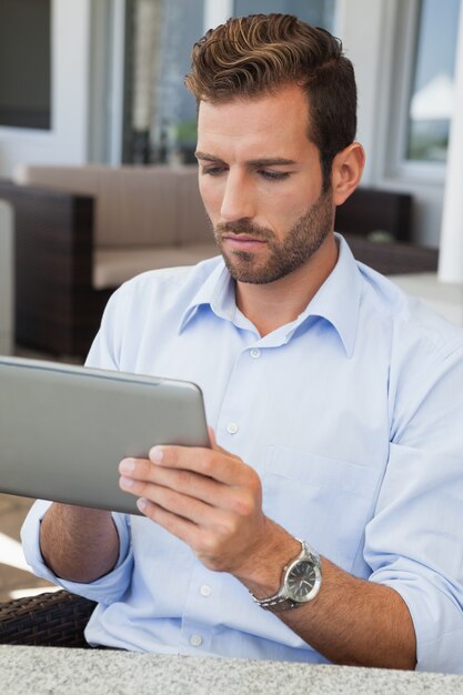 Serious young businessman working on tablet 