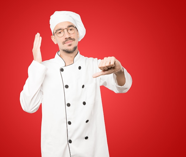 Serious young chef doing a gesture of defeated