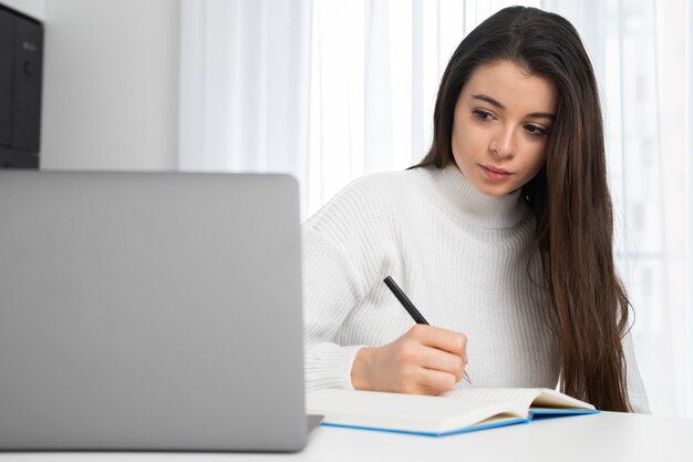 Serious young lady in stylish wear attends online lecture