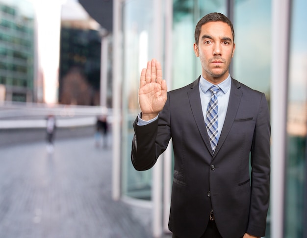 Serious young man doing a stop gesture