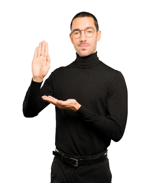 Serious young man making a gesture of stop with his palm