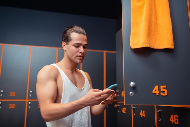 Serious young man standing in the changing room