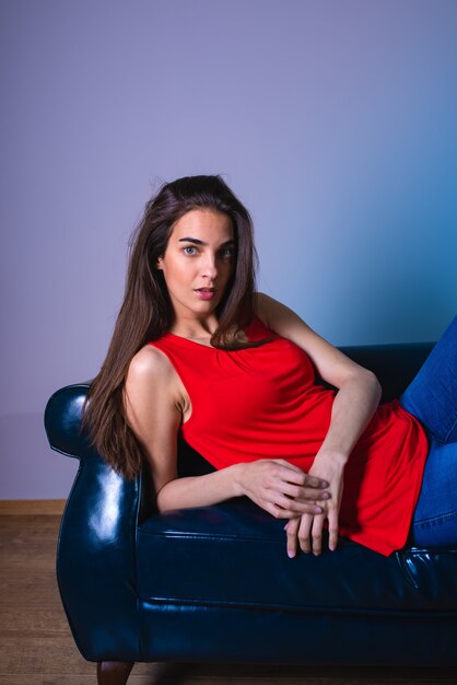 A serious young woman lying on a sofa